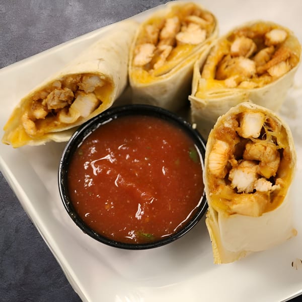 Four chicken and cheese flautas with a side of red salsa on a white plate.